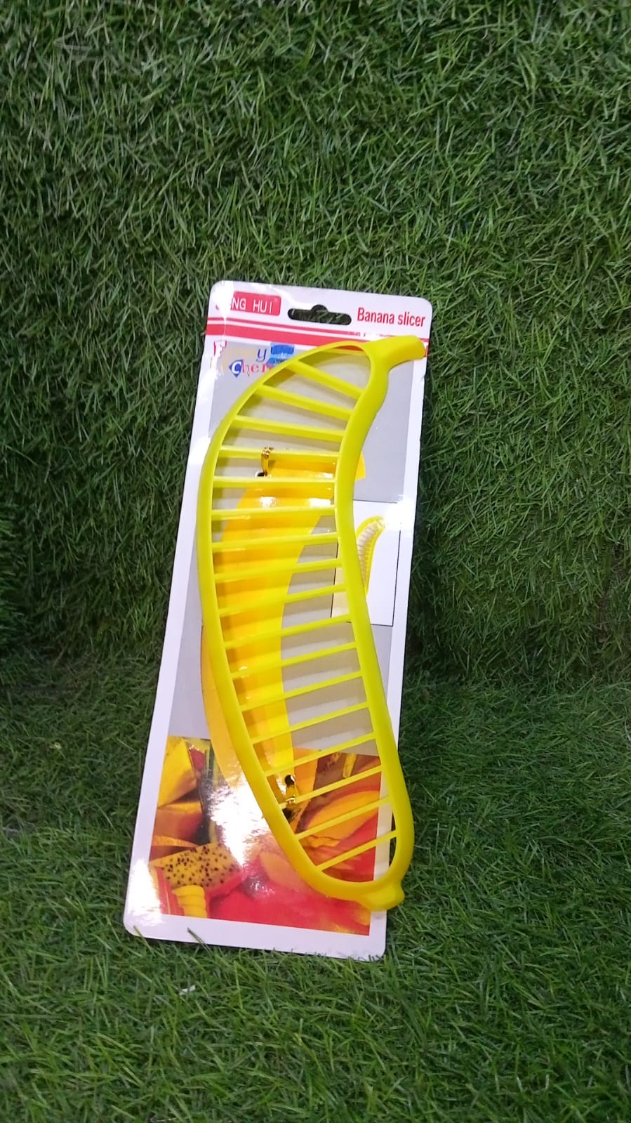 Plastic banana slicer with handle, for cutting fruit into slices for salads.