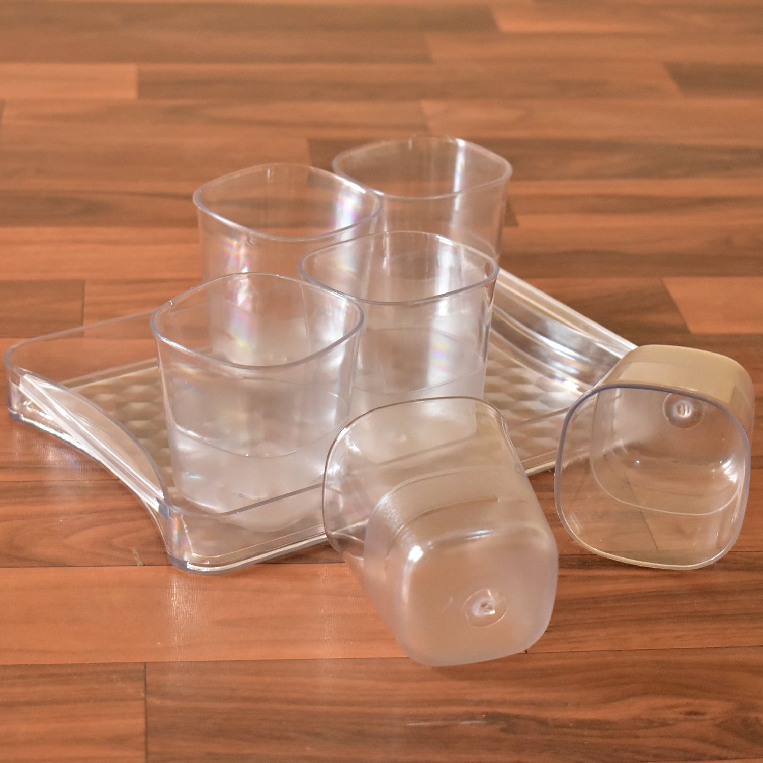 Transparent glasses set with tray for multiple drinks.