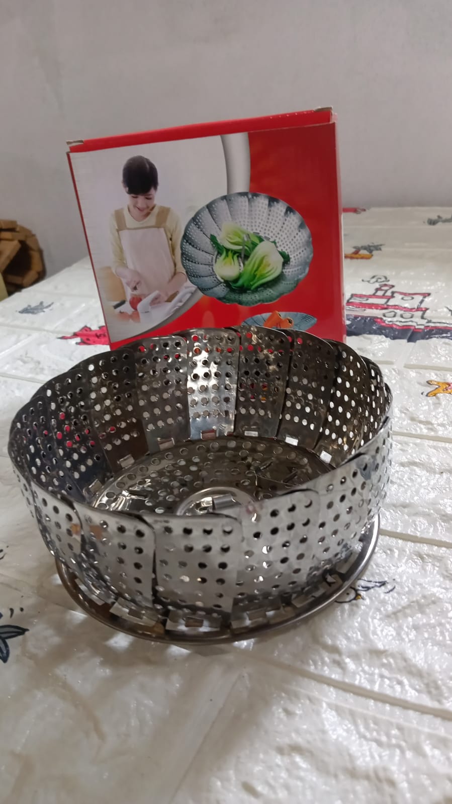 Stainless steel foldable basket for steaming and drying dishes.